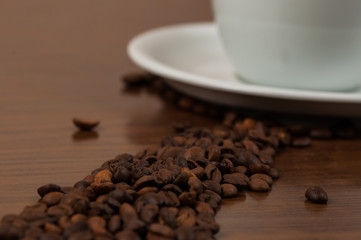 White coffee cup and coffee beans on a wooden table.Coffee time