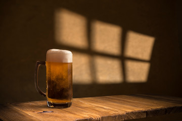 Beer barrel with beer glasses on a wooden table. The dark brown background.
