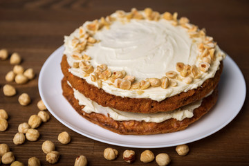 Carrot cake and hazel nuts on the wooden table