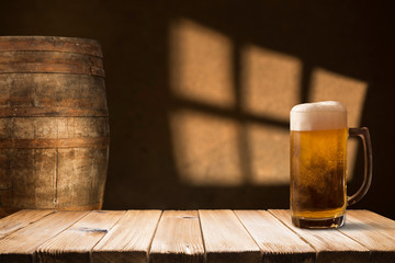 Beer barrel with beer glasses on a wooden table. The dark brown background.
