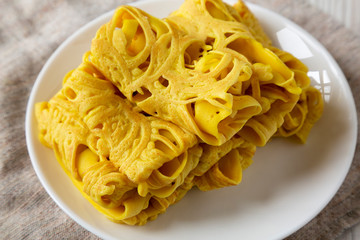 Homemade Net Crepe Roti Jala on a white plate, low angle view. Close-up.