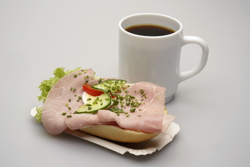 Ein Halbes Belegtes Brötchen mit Schinken, Tasse Kaffee