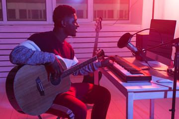 Musician and making music concept - African american male sound producer working in recording studio.