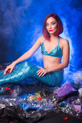 Fototapeta na wymiar Ocean plastic pollution. Cute mermaid swimming in water with plastic garbage. Stop plastic pollution. Fairy tale and reality concept.