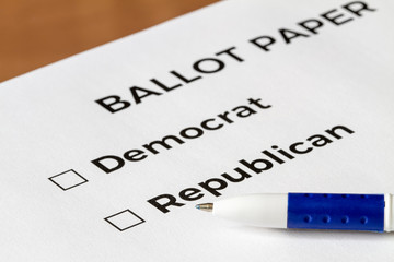 Checklist concept. Closeup of ballot paper with words Democrat and Republican with checkboxes and pen on it.