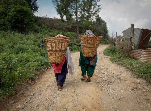 Two People Carrying Bamboo Baskets