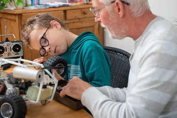 grandpa and son little boy repairing model radio-controlled car