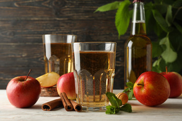 Composition with cider, cinnamon and apples on wooden background