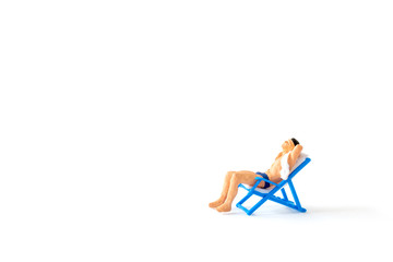 Miniature people sunbathing on deck chairs on white background , Summer time concept