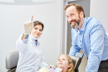 Fototapeta premium Kinderzahnarzt und ZFA erklären die Behandlung