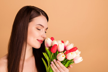 Profile side close up photo of charming woman hold blossom bouquet tulips gift 8-march celebration spring holidays given after spa salon procedure smell aroma enjoy isolated beige color background