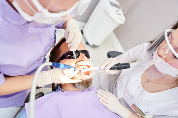 Zahnarzt und Zahnarzthelferin bei der Behandlung