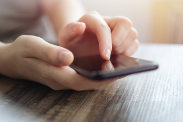 Vintage close up of woman hands holding smartphone, touching a mobile phone screen. Online communication concept
