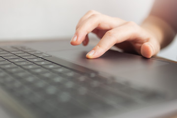 Close up macro of hands typing on black laptop computer keyboard. Work online or internet concept