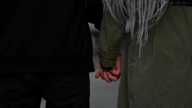 Young happy loving couple walking outdoors at the street having fun. Couple Holding Hands. Couple in love fun and joy hugging spinning together. woman with dreadlocks. kiss