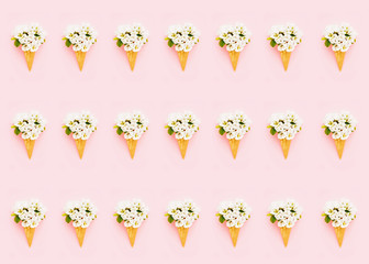 Pattern. Waffle ice cream cone with blooming pear flower on pink background. Spring concept. Copy space for text, top view