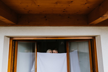 Young man and woman in sheets on the balcony.