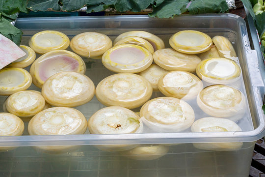 Close up of group of fresh artichokes hearts in  plastic bowl