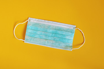 medical or surgical mask - protective face mask flat lay on yellow background