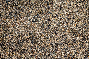 small crushed stone lies on the ground of orange color