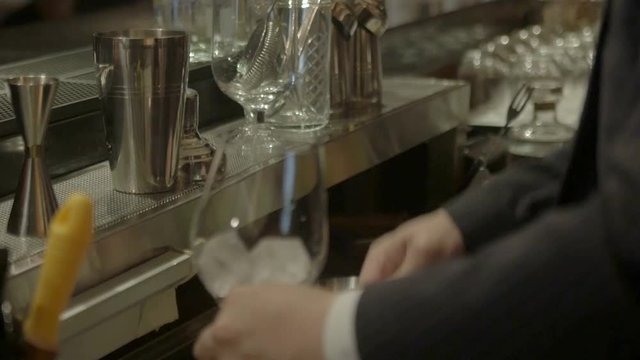 man pouring ice into the glass - pan follow