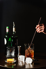 Whiskey with orange and ice close-up. A whiskey cocktail is prepared at the bar.