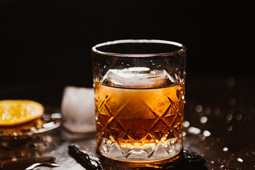 Whiskey with orange and ice close-up.