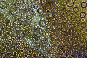 The pattern of interwoven rings of different diameters of white, purple and copper colors is...