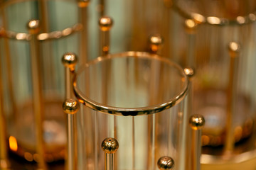 Golden Spiral for room decoration. Openwork festive golden vase  on blurry background. Close up of a golden sphere