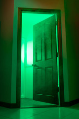 Obraz premium Open door with a smoky room. UV green light. Copy space. Hazard or chemical experiments