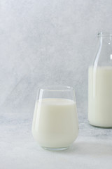 A glass and bolt with fresh milk on light background with copy space. Dairy products.