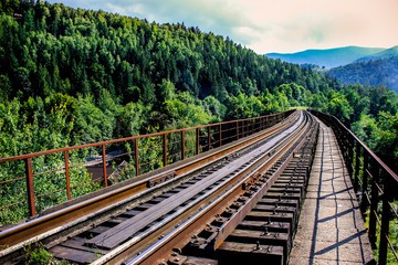 Railroad to the mountains. The road is laid over the gorge. Around the mountains and forests.