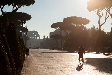 Zelfklevend Fotobehang Urban landscape in Rome (Italy): a person commuting by bike with the Coliseum in the background © Juan Baena