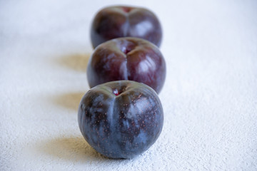 plums on a grey cocncrete background