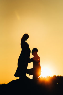 silhouettes of a happy young happy family against an orange sunset