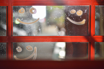 The smile face made by white color spray on window glass in x mas season