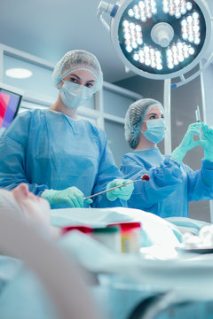 Doctors operating their patient and looking concentrated stock photo