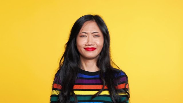 Asian woman say yes and then say no on yellow background