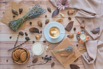 Cup of cappuccino with latte art on wooden background. Autumn flat lay composition. Cozy breakfast. Top view