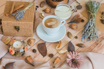A cup of coffee with milk on a wooden table. Autumn mood. Cozy autumn composition. Morning breakfast