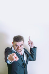 Make your choice. Portrait of handsome businessman wearing suit pointing at You and up. Free copy space for design and text.