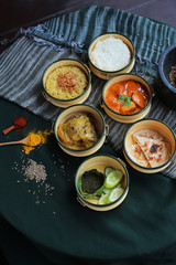 Stylish Indian dishes in pinto lunchbox shot with props