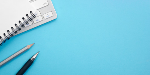 Blue desk office with laptop, smartphone and other work supplies with cup of coffee. Top view with copy space for input the text. Designer workspace on desk table essential elements on flat lay