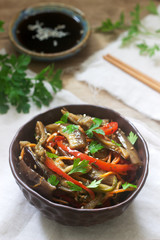 Oriental style vegetable salad with eggplant, soy sauce and chopsticks on a wooden table. Rustic style.