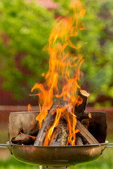Branches on fire, bonfire, firewood burn, fire, igniter for home grill, preparation of coals for frying shish kebab. Summer campfire in the grill