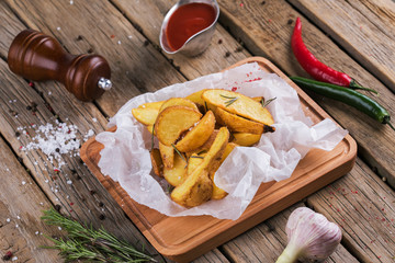Fototapeta premium Baked potato wedges with herbs and ketchup decorated with dill.