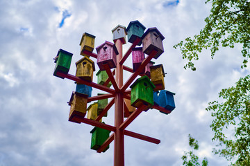 colored birdhouses on a background of blue sky