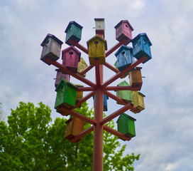 colored birdhouses on a background of blue sky