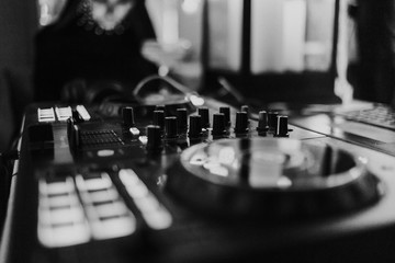 Dj deck controls in black and white. Blurred background
