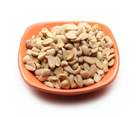 Roasted peanuts pile, savory snacks in porcelain bowl isolated on white background